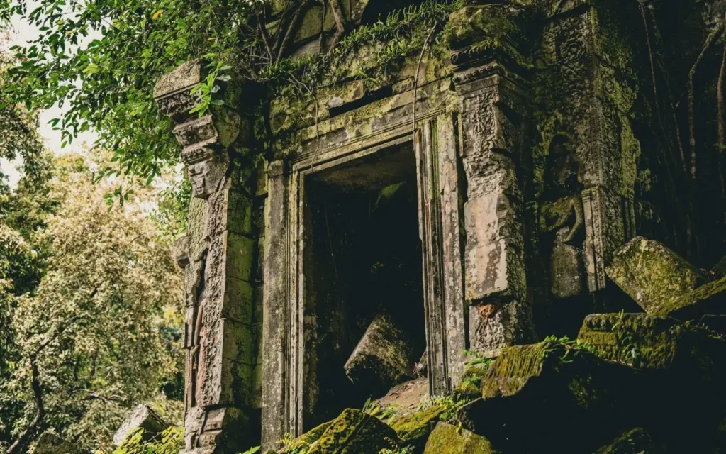 Ancient stone temple ruins covered in moss and surrounded by tropical forest at Beng Mealea, Cambodia