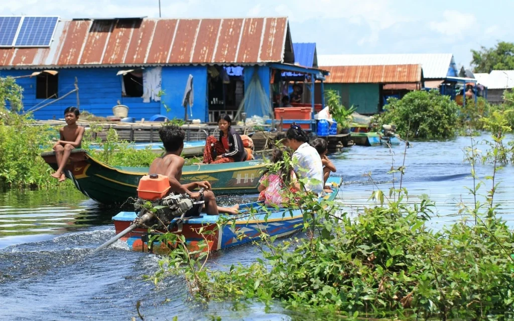 Traditional wooden stilt houses and boats at a floating village on Tonlé Sap Lake, Cambodia.