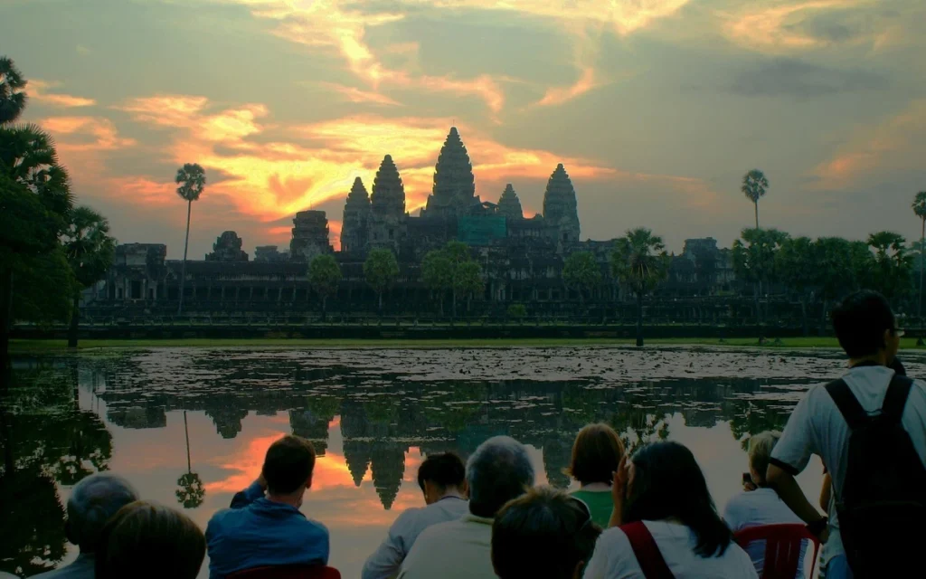 Angkor Wat temple silhouetted against the sunrise and reflected in water in Siem Reap, Cambodia.